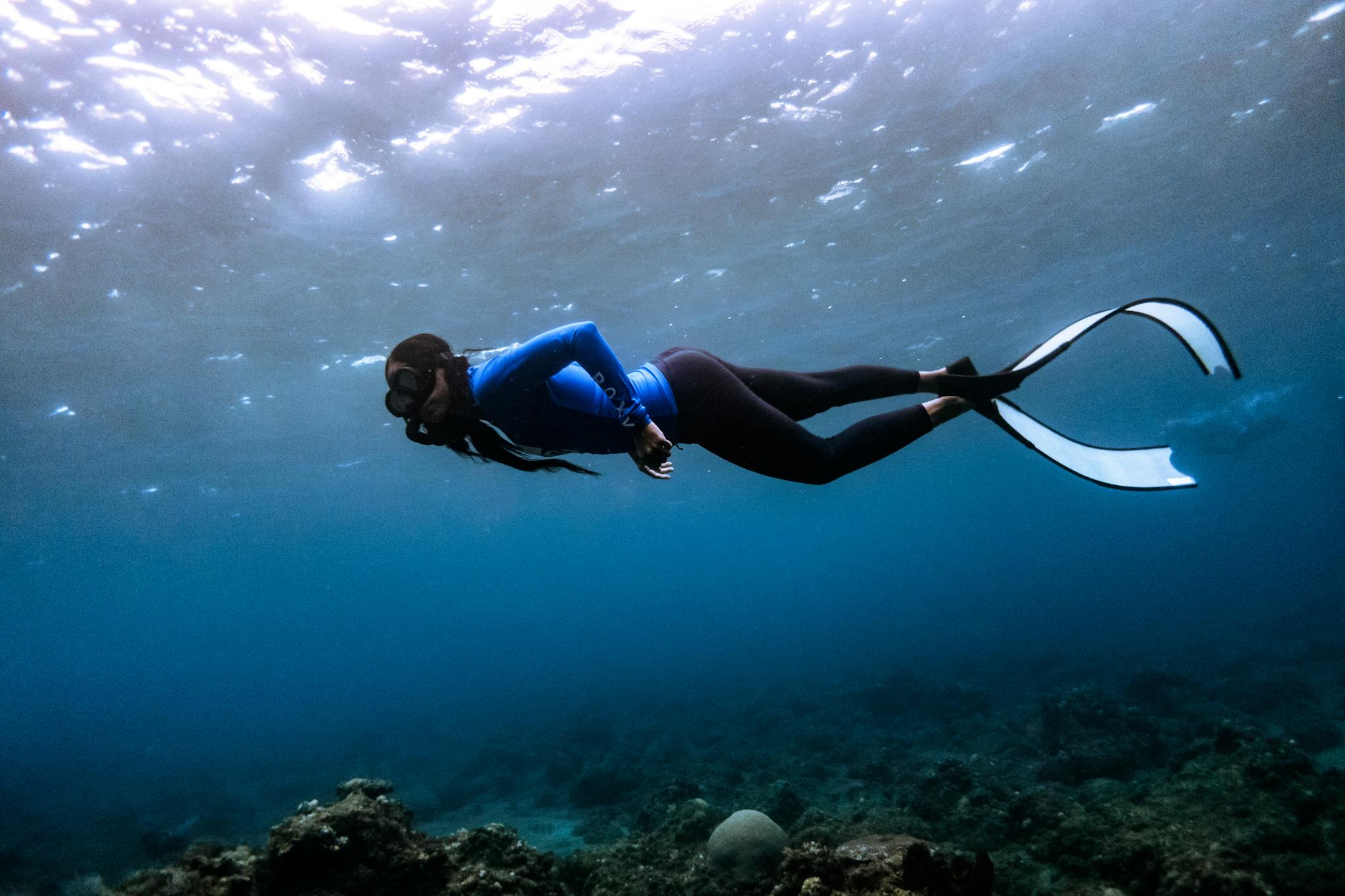 Explore the vibrant underwater world of Manado, North Sulawesi with a snorkeler gliding through the ocean.